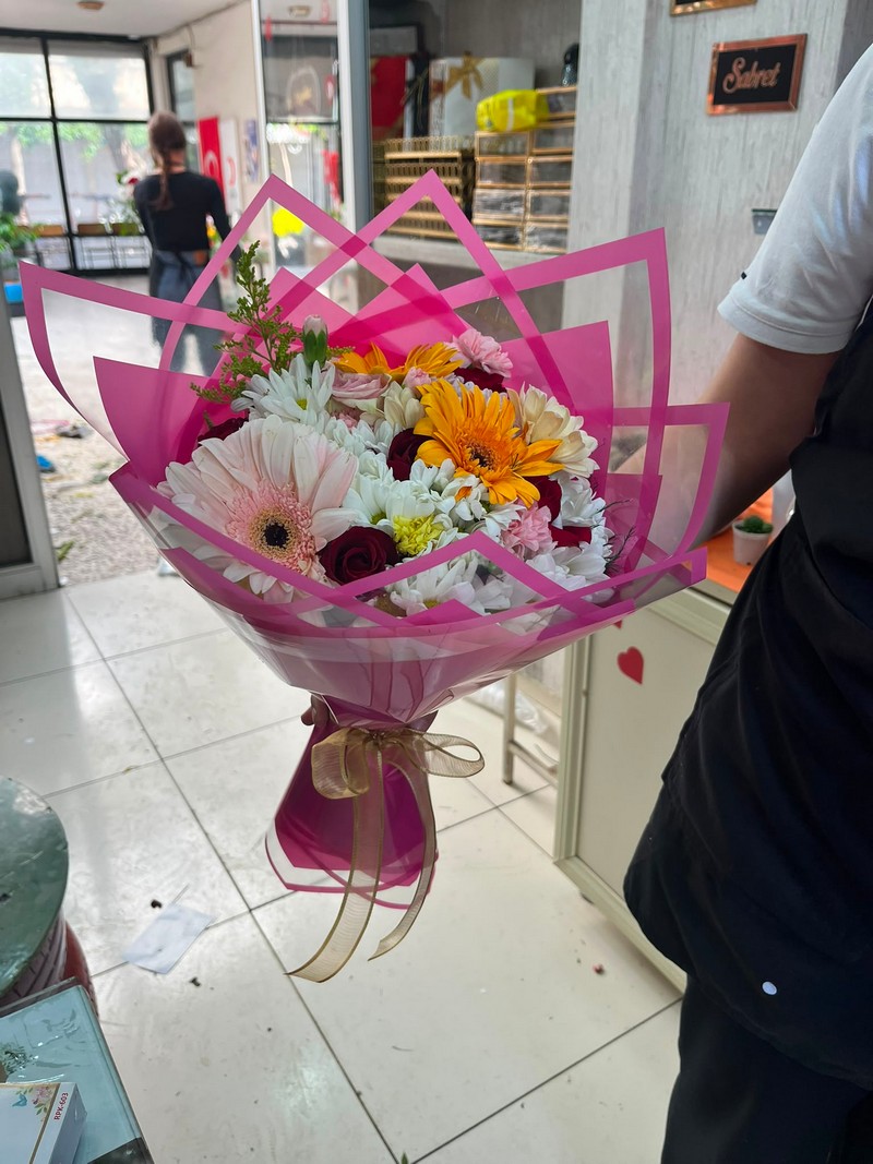 Pembe kenarlı ambalajda rengârenk çiçek buketi